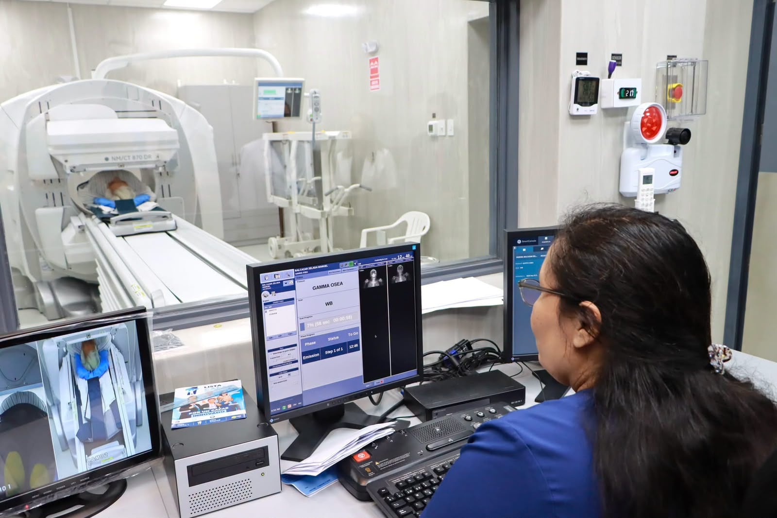 Una especialista en salud opera la consola de control durante un estudio de medicina nuclear en un hospital de EsSalud.