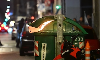 Parte trasera de un patrullero negro con luneta rota, luces azules en el techo, textos 'POLICIA DE LA CIUDAD', '911' y 'Ministerio de Seguridad BA'