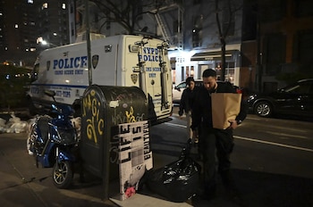 Una furgoneta de la unidad de escena del crimen de la policía de Nueva York estacionada en una calle de la ciudad por la noche, con personas caminando y un buzón en primer plano