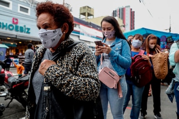 Personas con tapabocas hacen fila