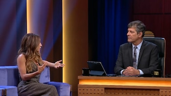 Eleonora Wexler, con cabello castaño y blusa sin mangas, gesticula sentada en un sofá morado frente a Mario Pergolini, quien viste traje y está en un escritorio