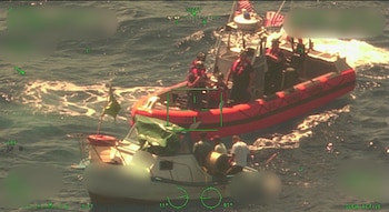 Una embarcación del guardacostas estadounidense presta asistencia a los ocupantes de una frágil nave a la deriva en el mar Caribe (Cortesía: Guardia Costera de EE. UU.).
