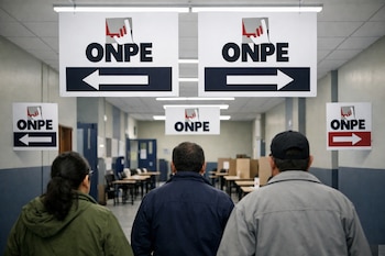 Interior de un pasillo ancho con paredes blancas y azules, techos con luces. Múltiples carteles blancos de ONPE con flechas guían. Tres personas de espaldas caminan.
