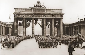 Desfile de tropas alemanas pasando por la Puerta de Brandemburgo en Berlín (Enciclopedia del Holocausto)