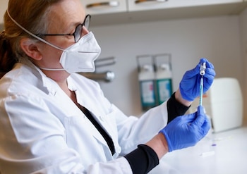 Una doctora prepara una jeringa