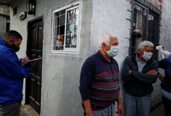 Un trabajador médico examina personas
