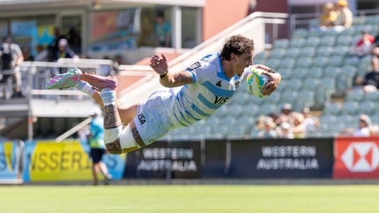 Luciano González de Los Pumas Sevens se lanza acrobáticamente para anotar un try crucial durante el torneo SVNS, exhibiendo la destreza del equipo argentino en el rugby sevens.