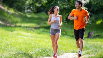 Una pareja corriendo por el parque (AdobeStock)