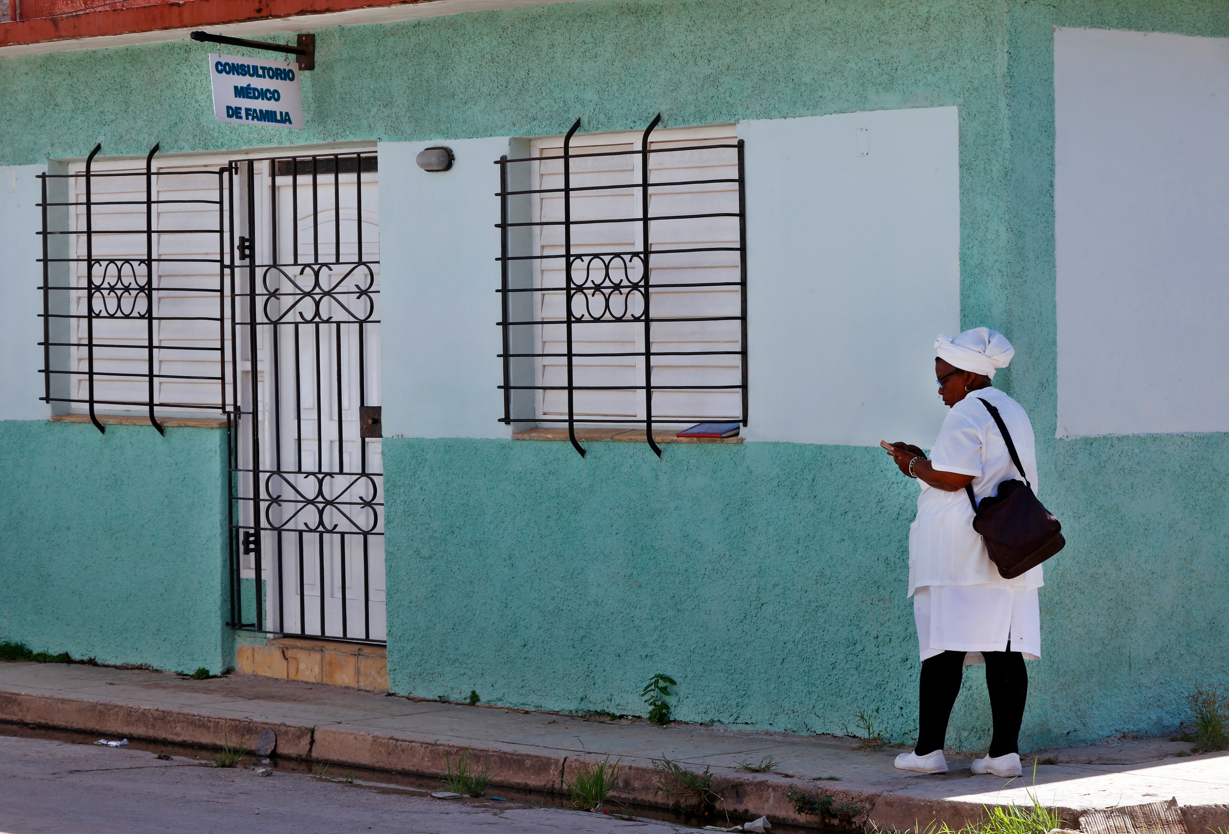 AME8923. PERICO (CUBA), 19/10/2025.- Una enfermera espera fuera de un consultorio médico este jueves en el poblado de Perico (Cuba). Es difícil, por no decir prácticamente imposible, encontrar a un vecino de Perico (60.000 habitantes, 170 kilómetros al sureste de La Habana) que no conozca a alguien que haya padecido chikunguña recientemente. EFE/ Ernesto Mastrascusa