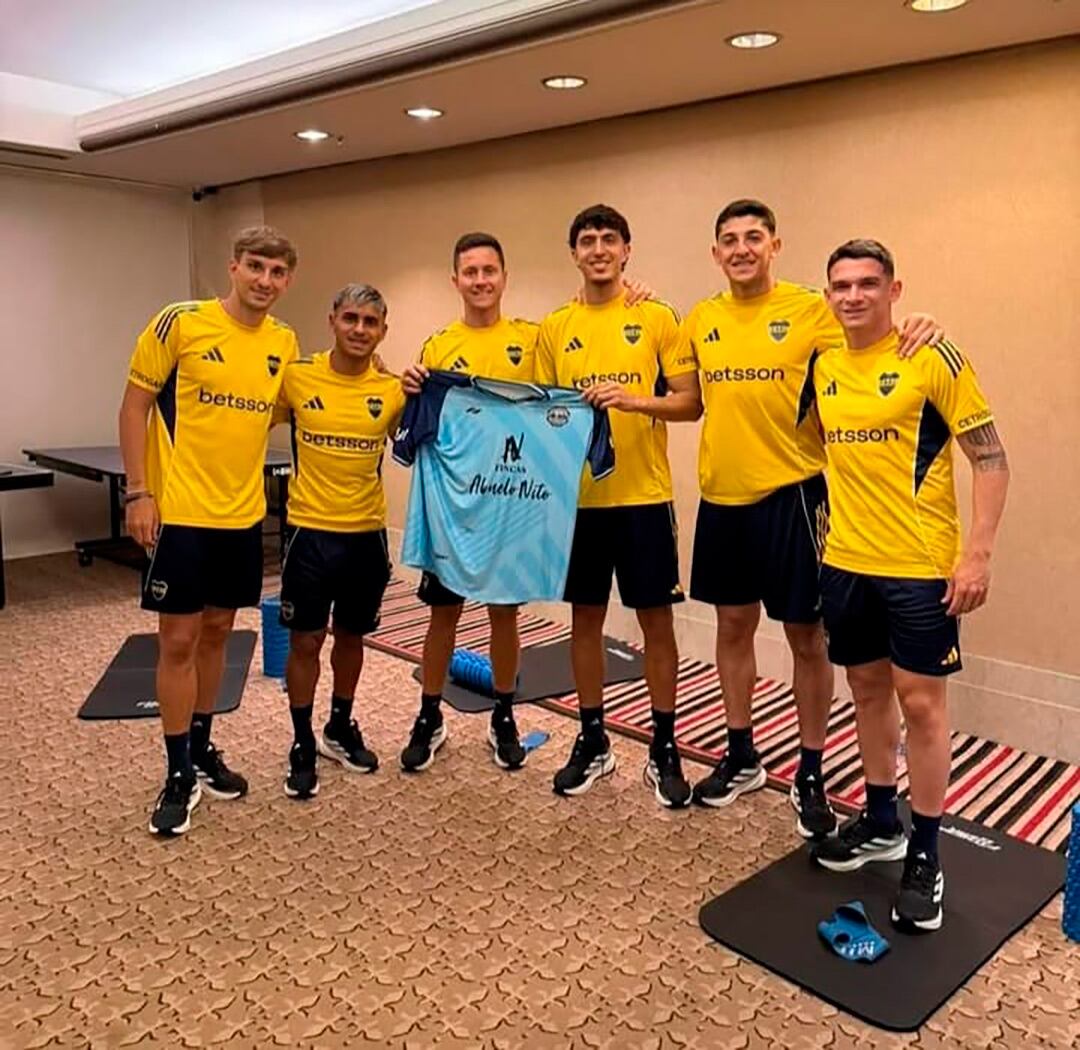 El defensor Mateo Mendía, surgido de Loma Negra, muestra la camiseta del club de Olavarría junto a sus compañeros de Boca