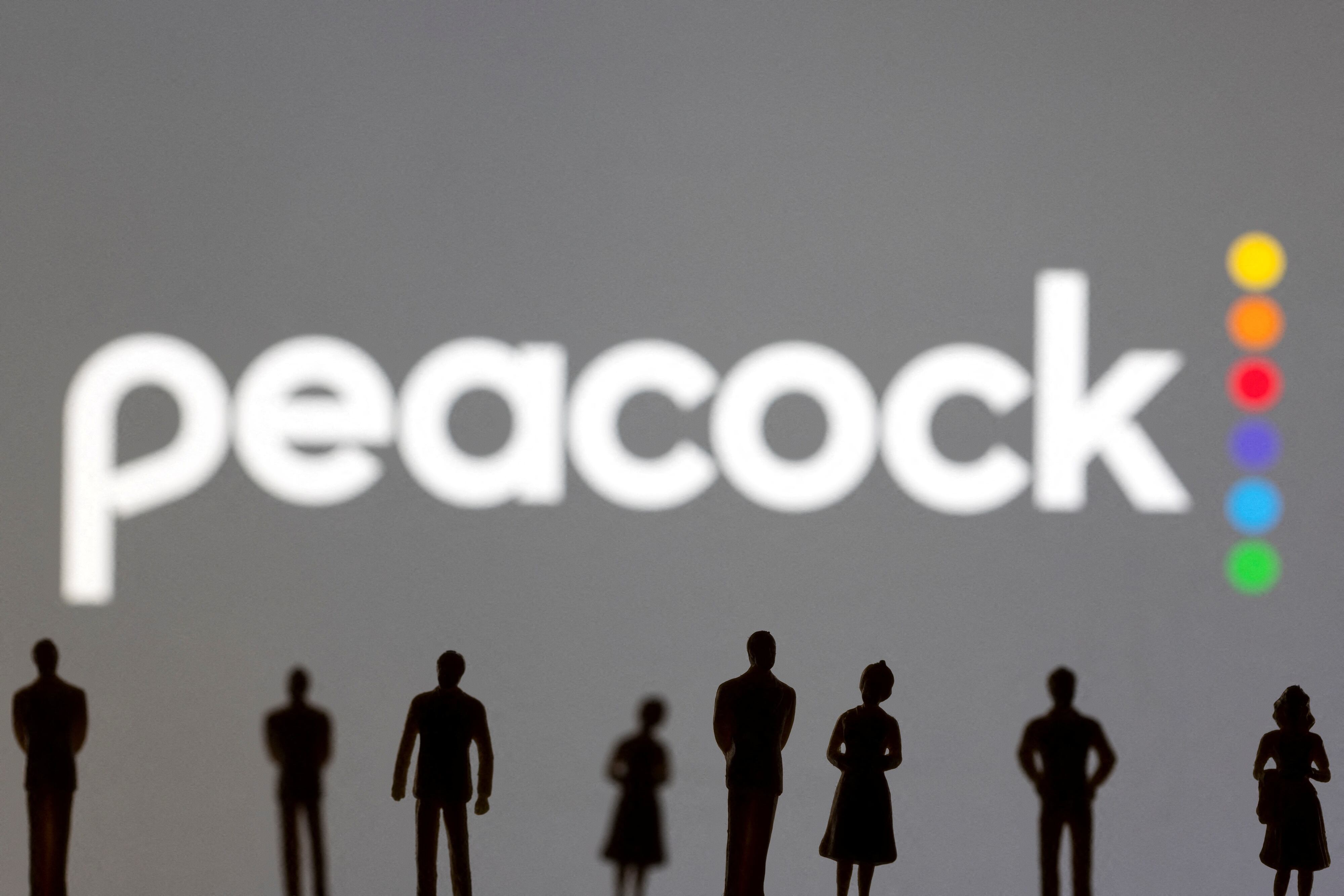 FILE PHOTO: Toy figures of people are seen in front of the displayed Peacock logo, in this illustration taken January 20, 2022. REUTERS/Dado Ruvic/Illustration/File Photo