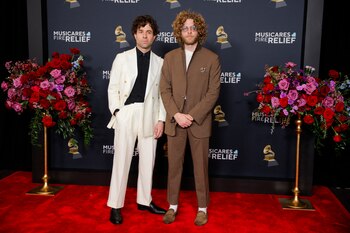 Taylor y Griffin Goldsmith, integrantes de Dawes, lucieron estilos contrastantes pero elegantes. Taylor optó por un traje blanco de corte clásico combinado con una camisa negra, aportando un look moderno y refinado. Por su parte, Griffin eligió un traje marrón con una camisa a tono, complementado con gafas y su característico cabello rizado