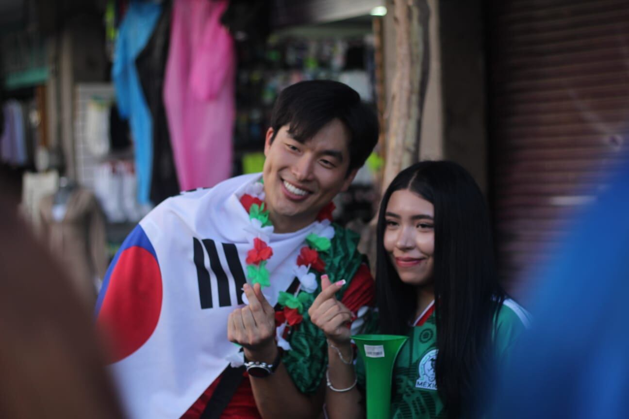 Aficionados de las selecciones de México y Corea del Sur interactúan en Guadalajara, con prendas representativas de sus países. ((Zurisaddai González/ Infobae México))