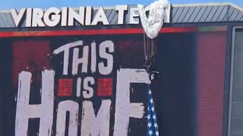 Paracaidista aterriza en cartelera de Virginia Tech con un mensaje inspirador