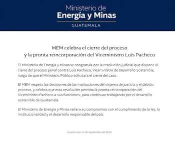 Personas en mesas con computadoras y micrófonos durante una sesión en una sala con la bandera de Guatemala