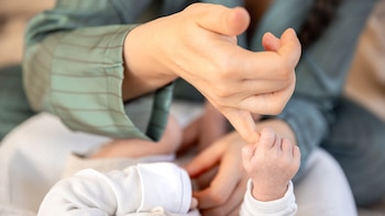 Una madre juega con su bebé recién nacido (Magnific)