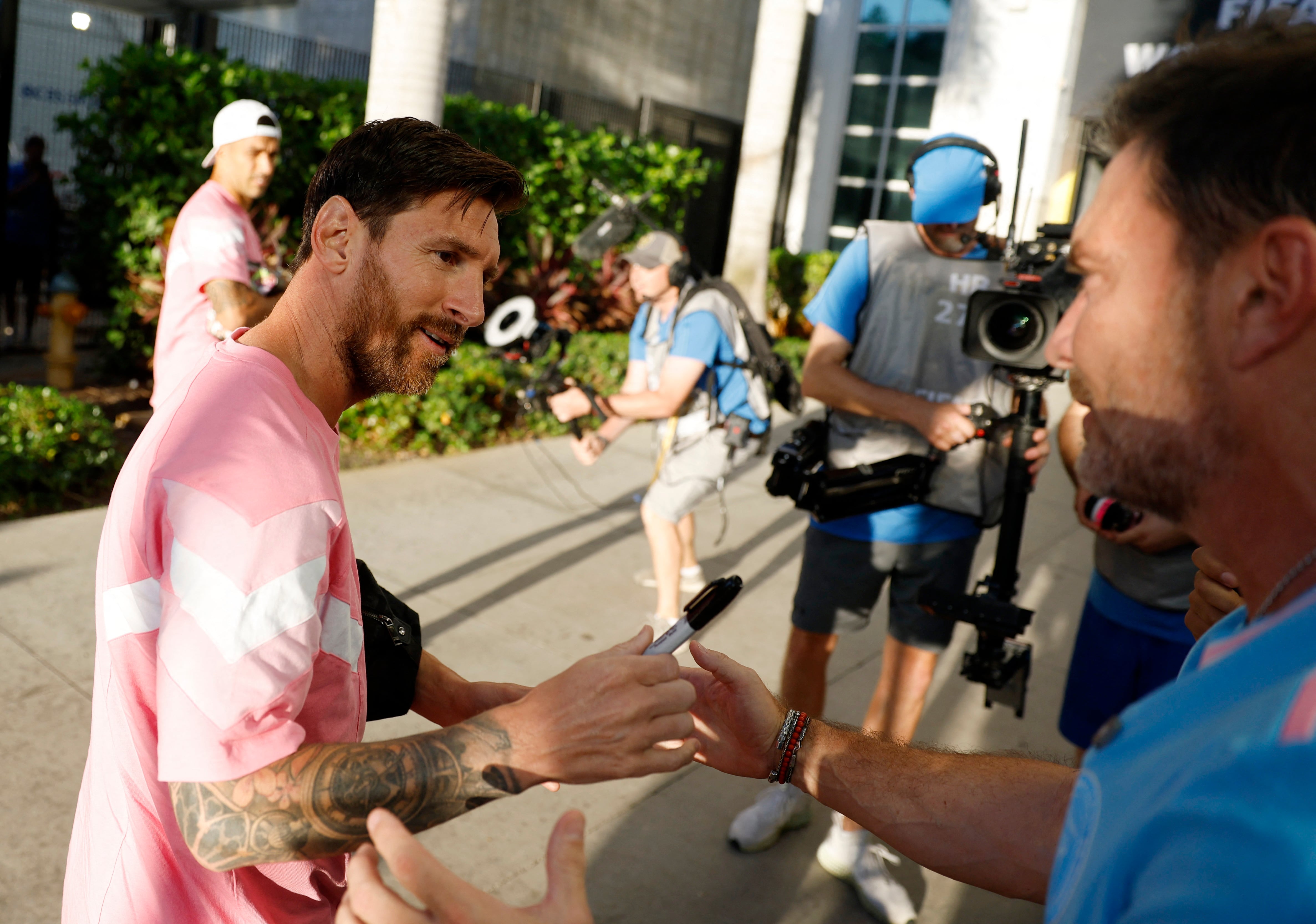 Leo Messi firmándole el brazo a un fan previo al partido contra Palmeiras - REUTERS/Marco Bello