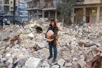 Un joven sobre los escombros