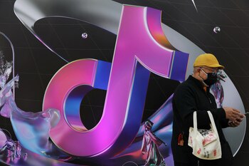Un hombre parado cerca de un letrero de la aplicación ByteDance Douyin durante la Semana de la Moda de China, en Beijing (REUTERS/Tingshu Wang/Foto de archivo)