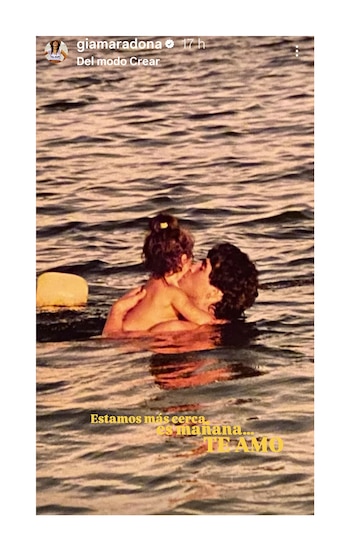 Una foto antigua de Diego Maradona y su hija Gianinna de niña en el agua, el padre la abraza y ella besa su mejilla, con burbujas y reflejos en la superficie