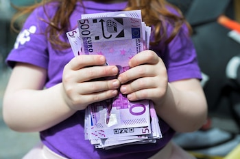 A girl holds fake 500