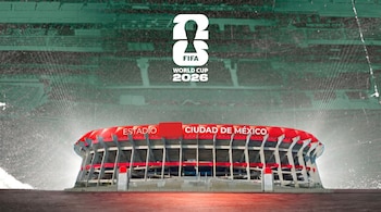 Un estadio moderno con techo rojo y "ESTADIO CIUDAD DE MÉXICO" en la fachada. El logo "FIFA World Cup 2026" se ve arriba. Fondo difuminado de gradas.
