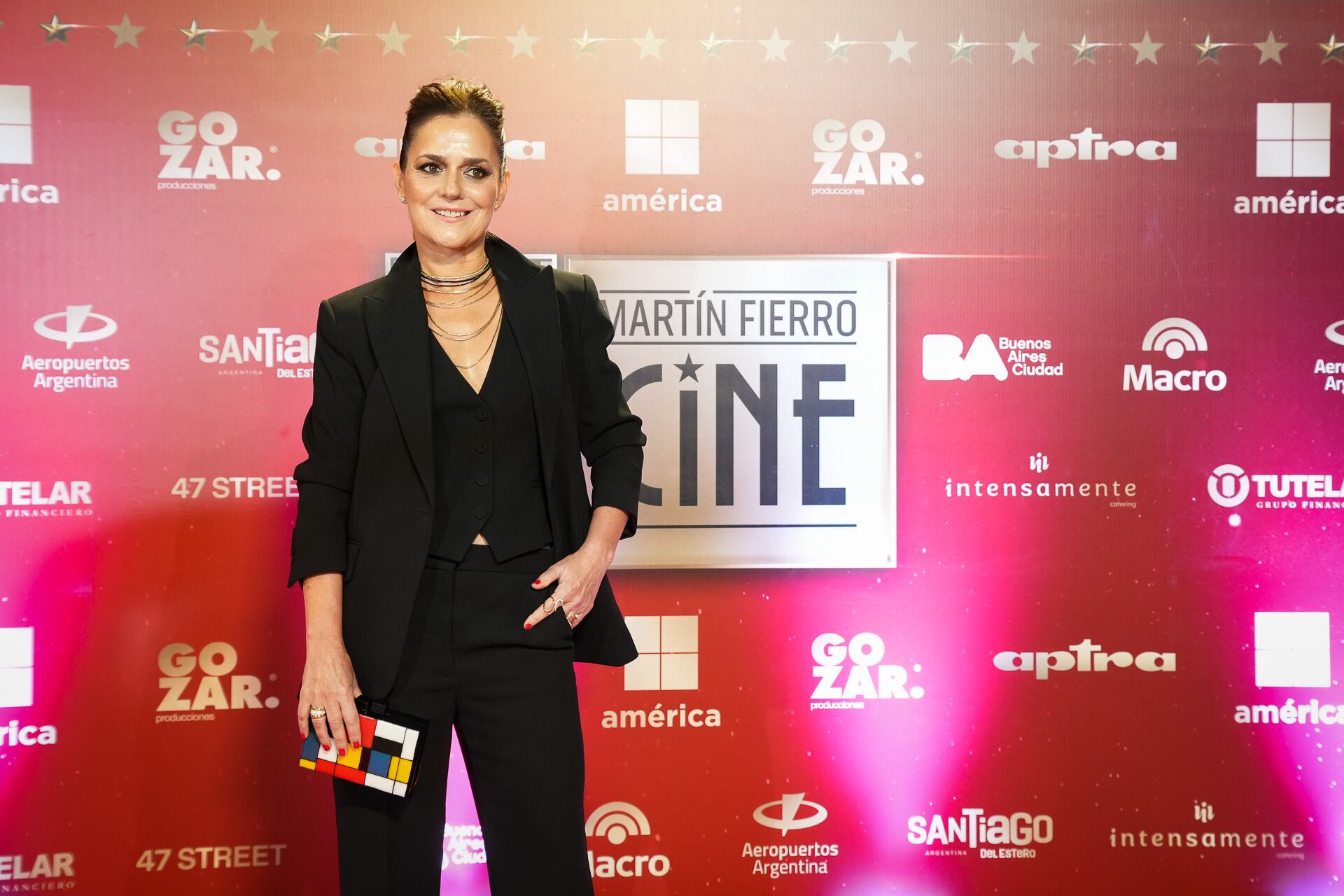 Pietra complementó con un collar dorado de varias vueltas y un clutch geométrico