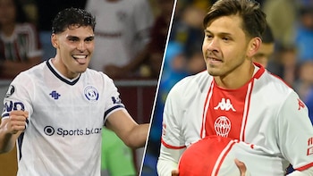 Dos hombres futbolistas sonríen; el de la izquierda viste camiseta blanca y azul, el de la derecha viste camiseta blanca y roja