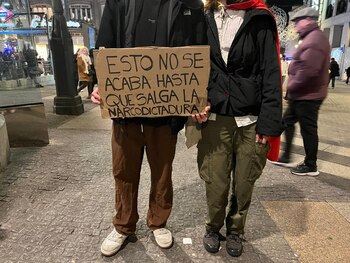 Dos jóvenes sujetan la pancarta
