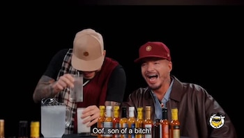 Ryan Castro aceptó el desafío de probar la quinta salsa picante de la entrevista, ante las risas de Balvin, que sabía que no iba a soportarlo - crédito Hot Ones