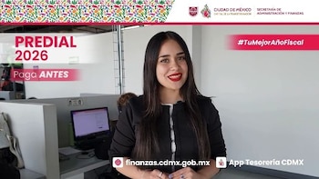 Una mujer sonriente posa en una oficina con cubículos y una laptop; varios banners promocionan el Predial 2026 de la Ciudad de México