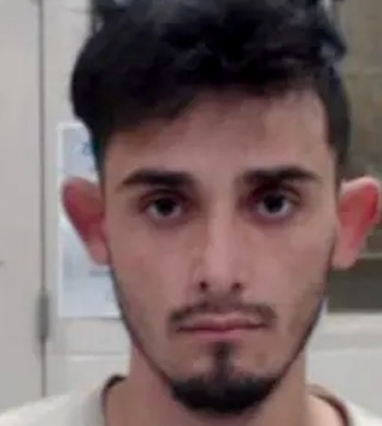 Primer plano frontal de un hombre joven con cabello oscuro, barba corta y ojos marrones, mirando directamente a la cámara