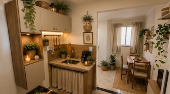 Cocina y comedor con gabinetes, mesada de granito, fregadero, freidora de aire, mesa, sillas, ventana, cortinas, plantas, cestas y velas.