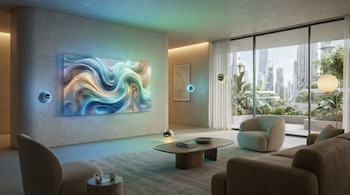 Sala de estar futurista con televisión inalámbrica en la pared mostrando arte abstracto. Esferas flotantes iluminadas controlan el ambiente. Muebles suaves y ventanal con vista urbana.