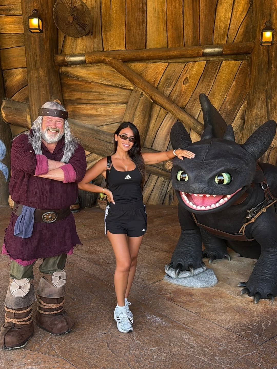 Antonela Roccuzzo disfruta de su visita a los parques de Orlando, posando alegremente entre un personaje disfrazado y una figura icónica de dragón.