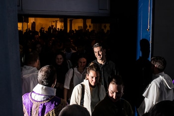 Miembros de la congregación de San José saludan a los feligreses después de la misa. (Bryan Anselm/Para The Washington Post)