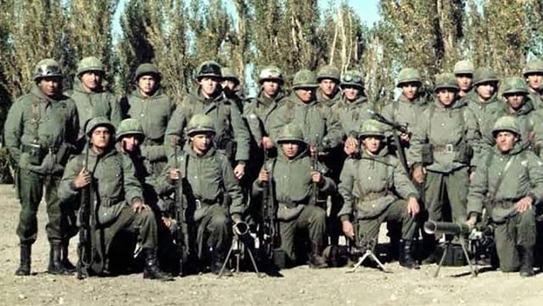 El entonces subteniente Villegas -el cuarto parado desde la izquierda, con antiparras en el casco- con su sección. Esta foto fue tomada el 1 de abril y solo él sabía que en horas volarían a las islas