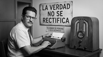 Hombre con camisa y gafas ante una máquina de escribir, junto a una radio de madera y un cartel con el texto La verdad no se rectifica.