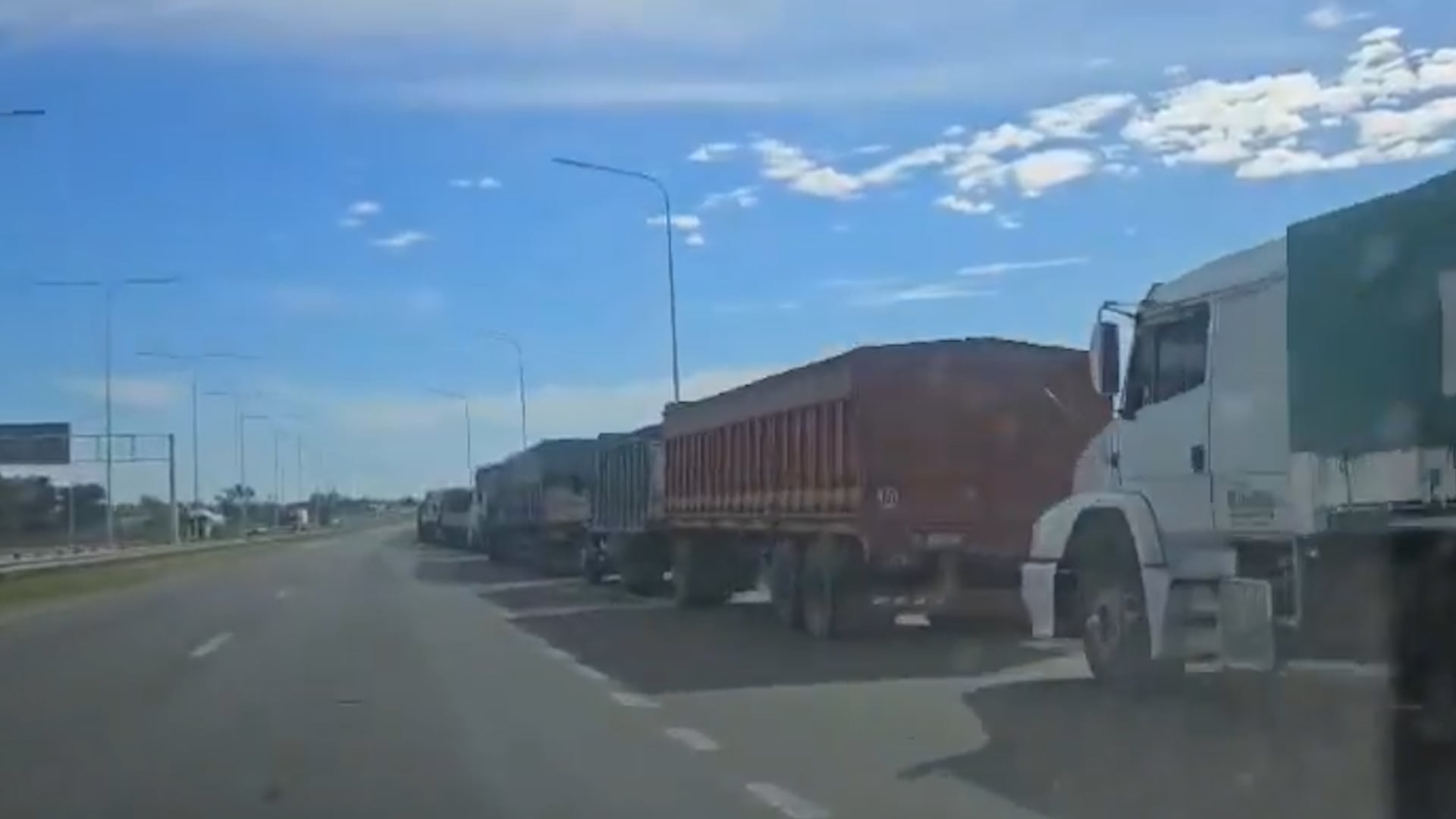 Largas filas de camiones avanzan lentamente hacia los puertos del cordón agroindustrial de Rosario, en plena campaña gruesa