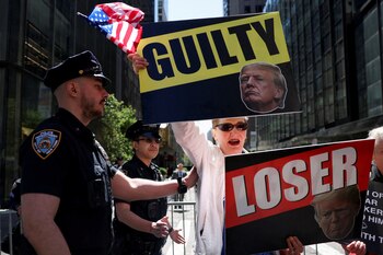 Un manifestante anti-Trump sostiene pancartas frente a la Torre Trump, el día después de un veredicto de culpabilidad en el juicio penal del candidato presidencial republicano y expresidente de Estados Unidos Donald Trump por cargos de que falsificó registros comerciales para ocultar el dinero pagado para silenciar a la estrella porno Stormy Daniels en 2016, en Nueva York, Estados Unidos, 31 de mayo de 2024. REUTERS/Andrew Kelly/File Photo