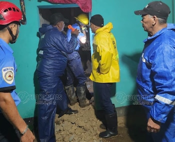 Integrantes de los equipos de emergencia y protección civil inspeccionan los daños en una vivienda de Jalapa, tras el colapso de un muro perimetral provocado por las intensas lluvias (Cortesía: Econoticia Jalapa).