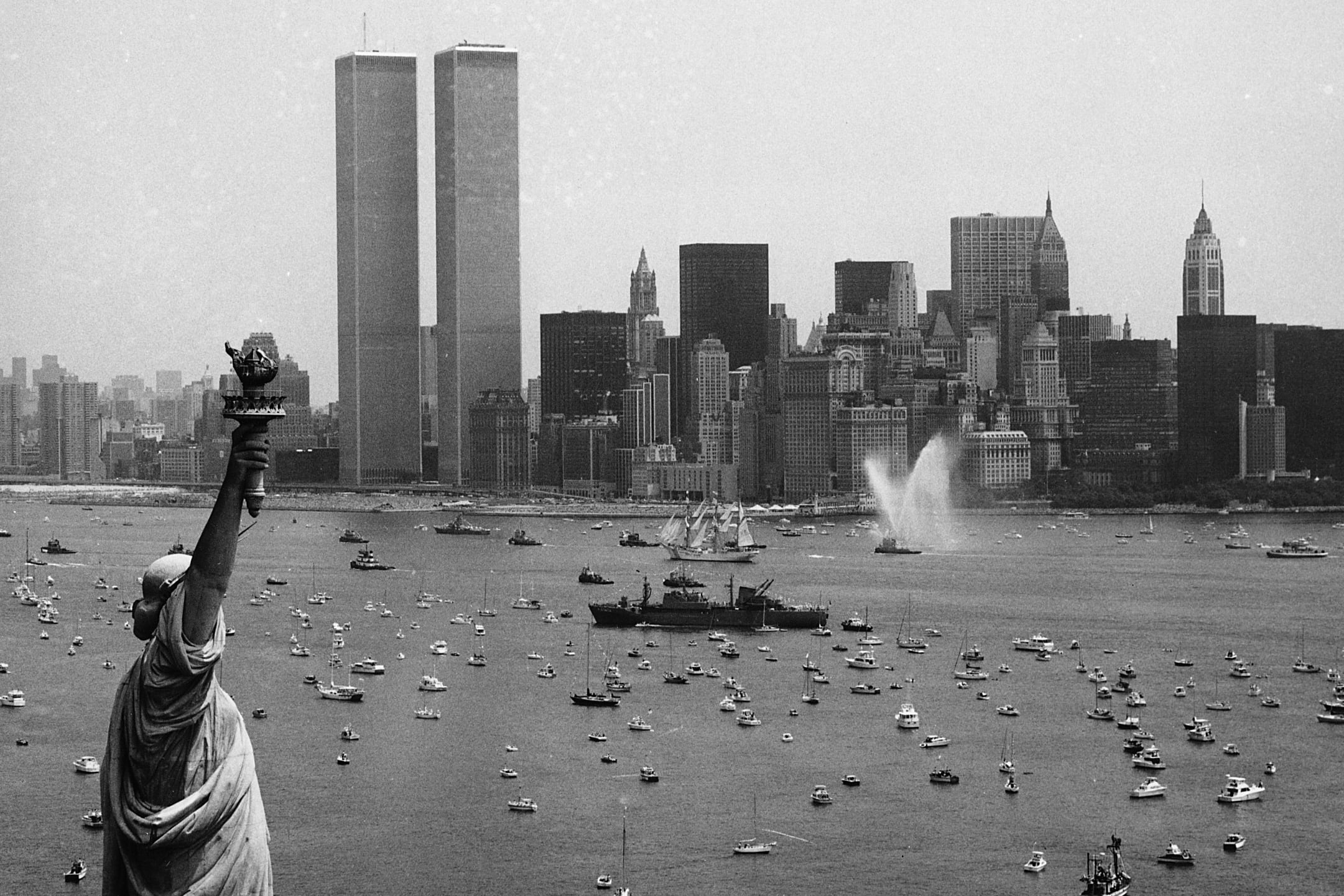 Diversas embarcaciones participan en la Operación Vela entre la Estatua de la Libertad y el World Trade Center para celebrar el bicentenario de la Independencia de Estados Unidos, el 4 de julio de 1976, en Nueva York. La Torres Gemelas aún estaban en pie (AP)