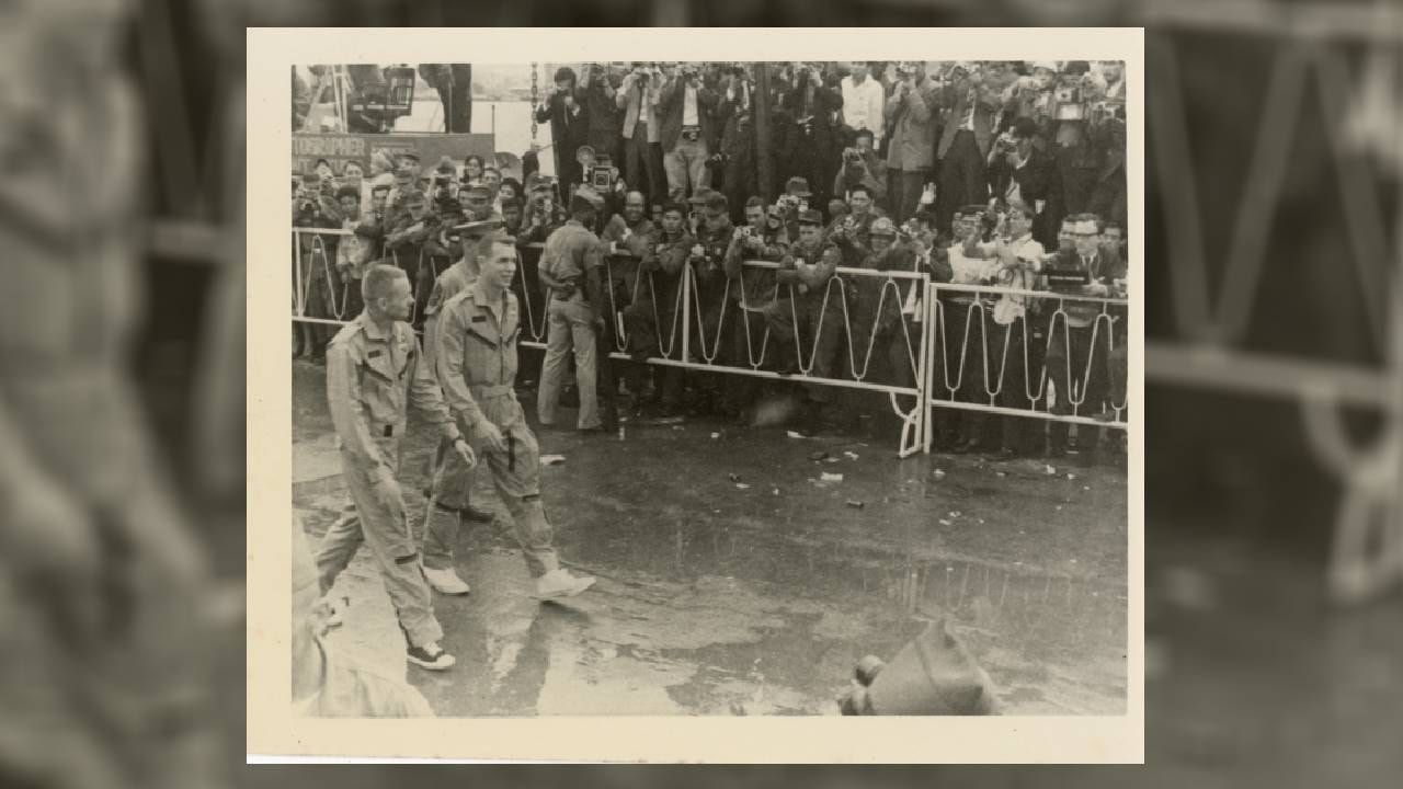 Los astronautas de la misión Gemini 8, Neil Armstrong y David Scott, son recibidos por una multitud entusiasta en una calle mojada tras su exitoso viaje. ((Ron Mc Queeney/Ohio History Connectio vía AP))