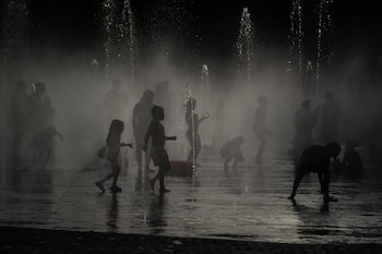 Varias personas se refrescan en las fuentes de Madrid Río, a 23 de junio de 2026, en Madrid. (Fernando Sánchez / Europa Press)