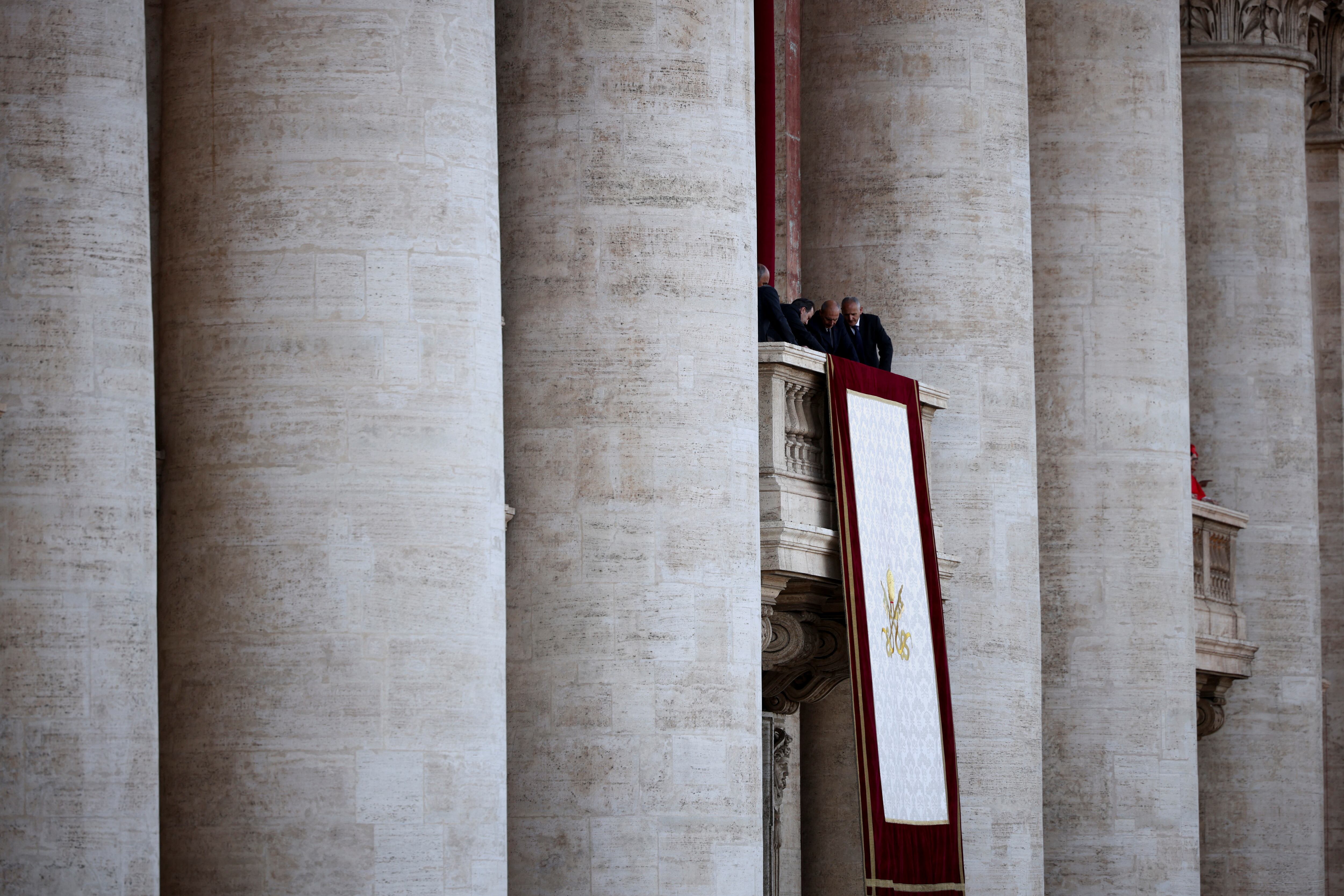 El personal del Vaticano despliega un tapiz papal, después de que el cónclave eligiera a un nuevo papa, en el Vaticano, el 8 de mayo de 2025