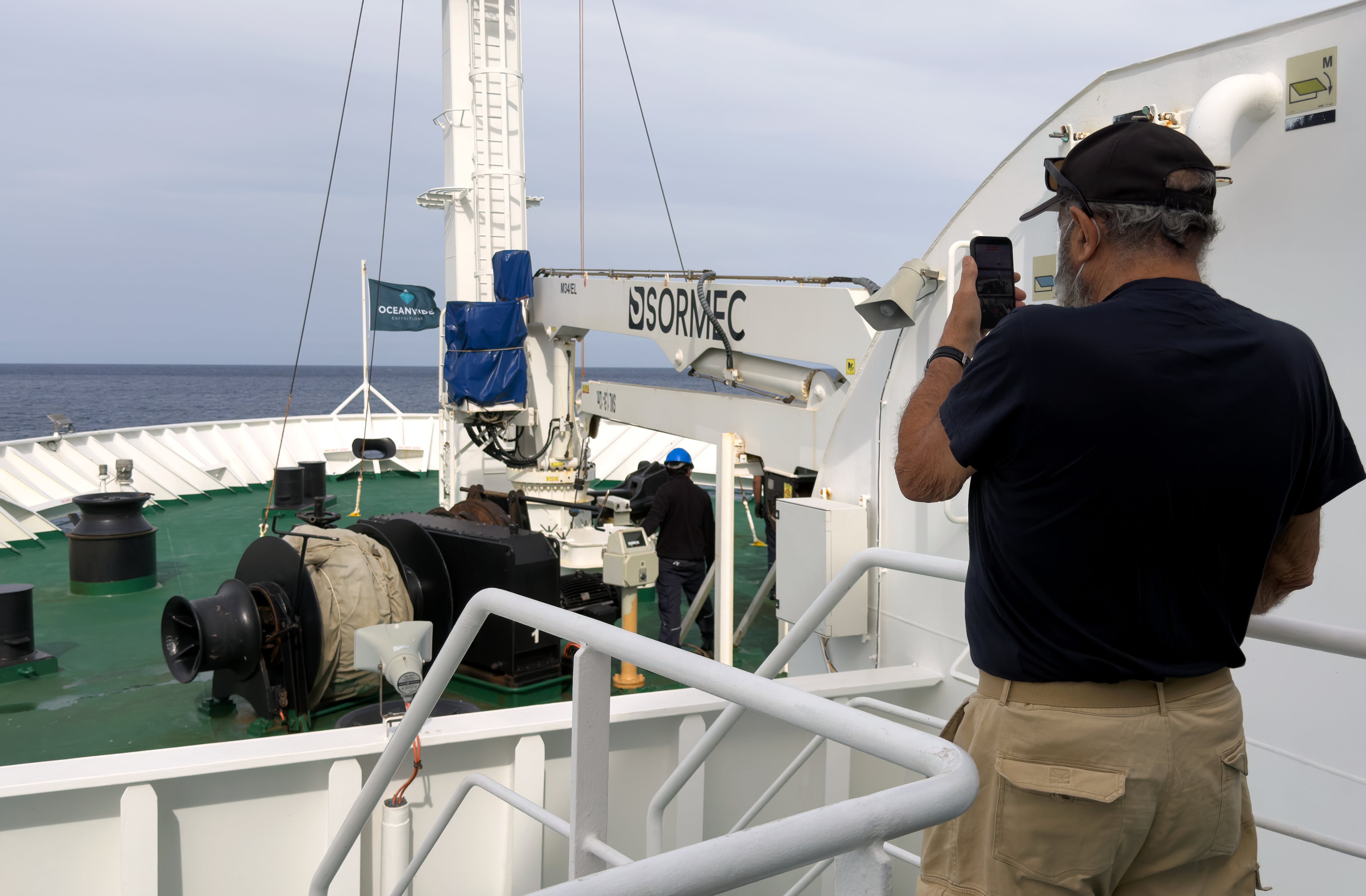 Un pasajero del MV Hondius, el crucero donde apareció un brote de hantavirus, toma una foto del ancla de la embarcación en Praia, durante una travesía hacia el puerto español de Tenerife (AP Foto)