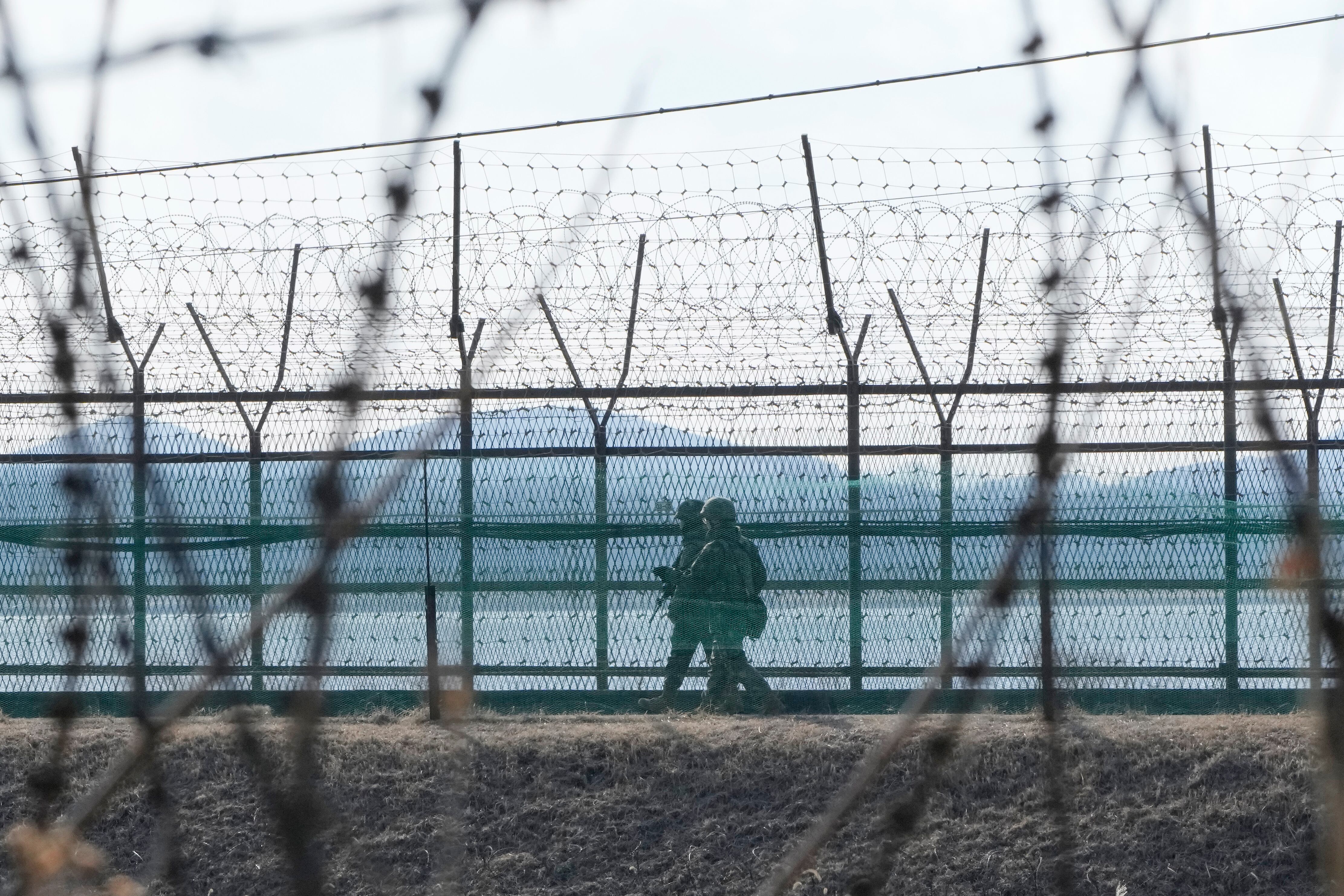 Soldados del ejército surcoreano patrullan junto a la cerca de alambre de espino en Paju, Corea del Sur, cerca de la frontera con Corea del Norte, el jueves 16 de febrero de 2023 (AP Foto/Ahn Young-joon)