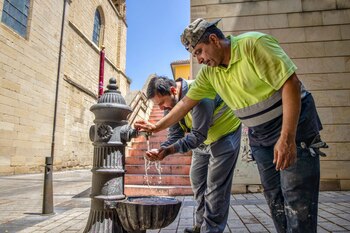 Unos trabajadores se refrescan en