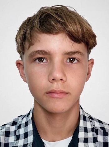 Primer plano de Jonathan David Muir, un joven con cabello castaño claro, ojos marrones y tez clara, luciendo una camisa a cuadros