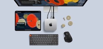 Apple Mac mini M4, teclado, ratón y iPad sobre una superficie azul claro. Se muestran pantallas con diseño de turbinas y engranajes de prototipo